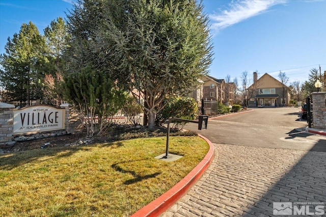 exterior space with curbs and a gated entry