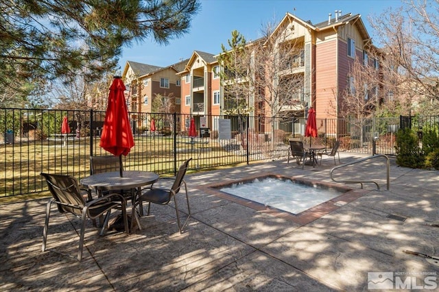 view of patio / terrace with fence and a hot tub