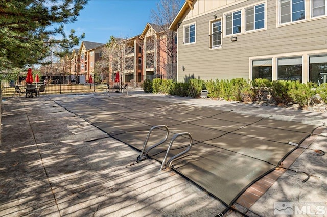 exterior space featuring a pool, fence, and a patio