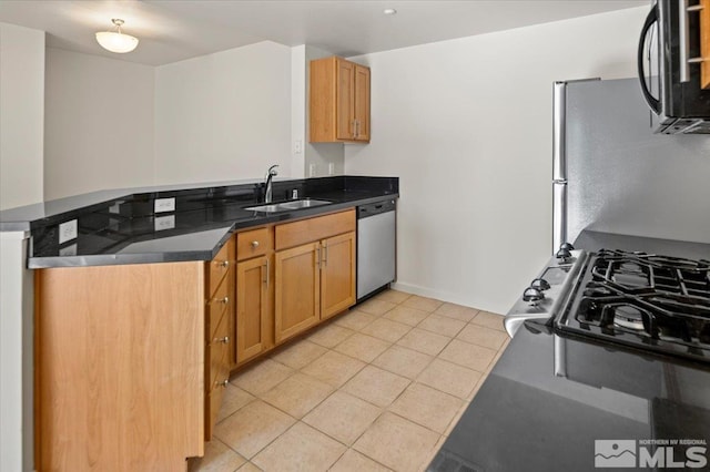 kitchen with a peninsula, light tile patterned floors, a sink, and stainless steel appliances