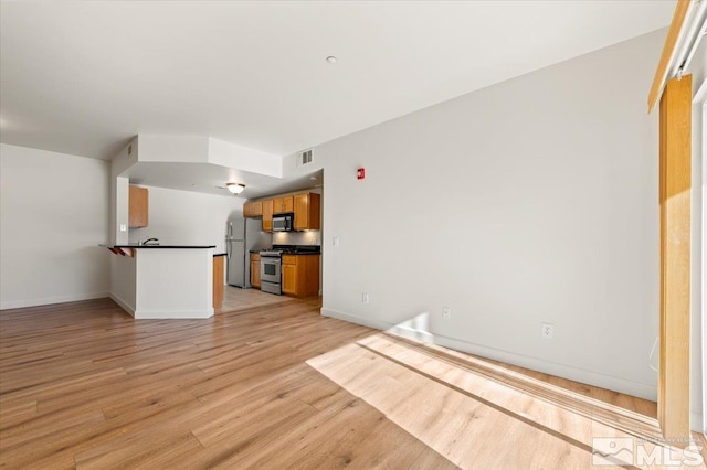 unfurnished living room featuring light wood-style floors, baseboards, and visible vents
