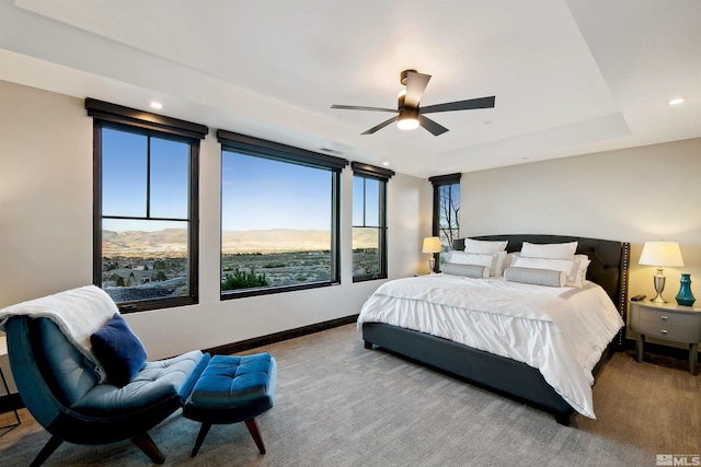 bedroom with recessed lighting, carpet floors, a raised ceiling, a mountain view, and baseboards