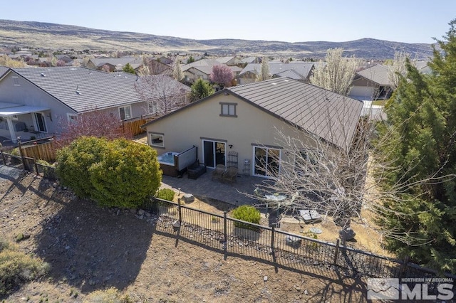 rear view of property featuring a patio area, a fenced backyard, a residential view, and stucco siding