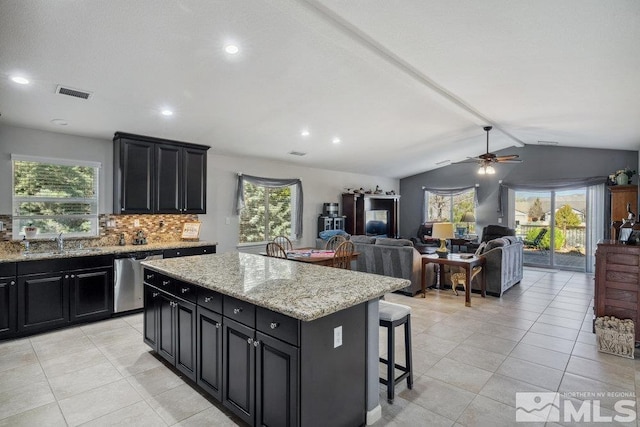 kitchen with a sink, visible vents, stainless steel dishwasher, and dark cabinets