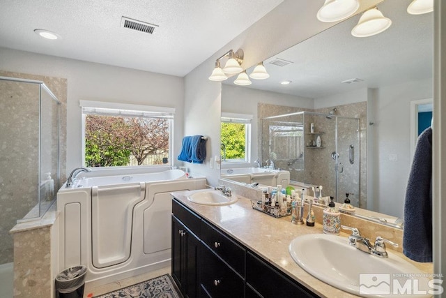 full bathroom featuring a sink, visible vents, a bath, and a shower stall