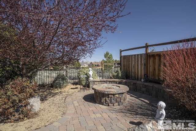 view of patio / terrace featuring a fire pit and fence
