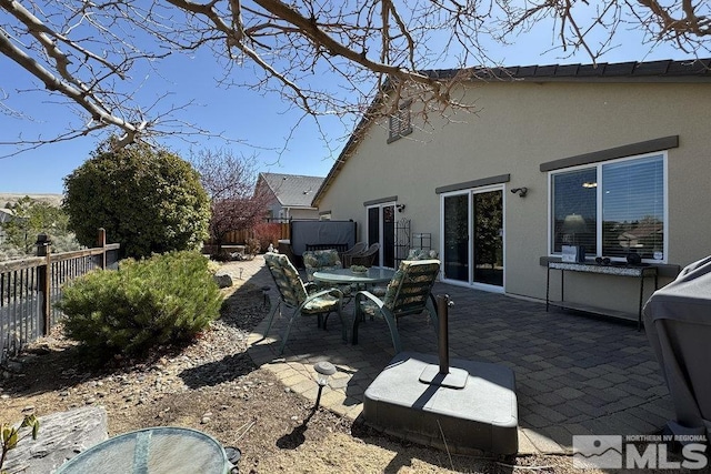 back of property with a patio area, fence, outdoor dining area, and stucco siding