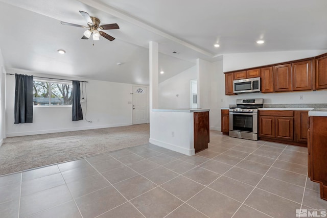 kitchen featuring vaulted ceiling, open floor plan, brown cabinets, appliances with stainless steel finishes, and light colored carpet