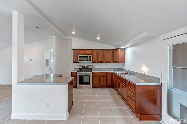 kitchen with visible vents, a sink, appliances with stainless steel finishes, brown cabinets, and lofted ceiling