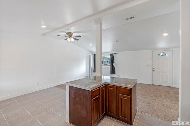 kitchen with lofted ceiling with beams, a ceiling fan, visible vents, open floor plan, and tile counters