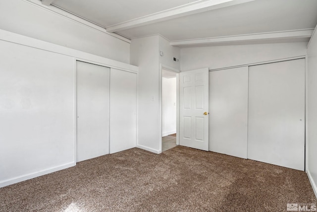 unfurnished bedroom with lofted ceiling with beams and carpet