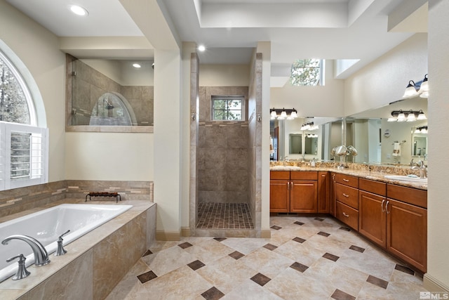 bathroom featuring a garden tub, double vanity, a sink, and walk in shower