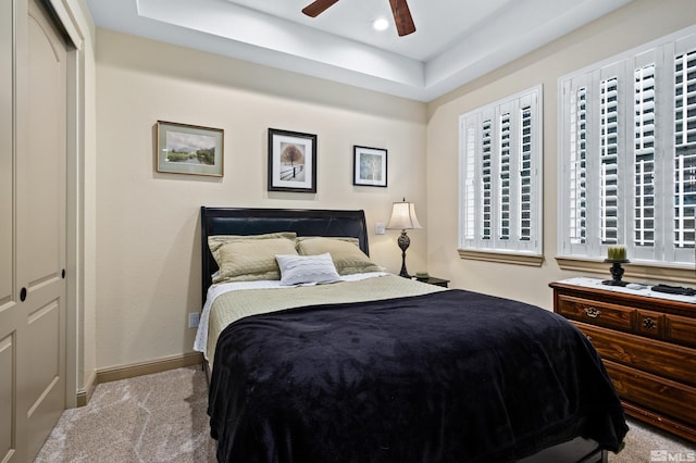carpeted bedroom featuring a closet, baseboards, a ceiling fan, a tray ceiling, and recessed lighting