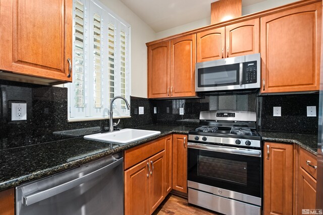 kitchen featuring a sink, brown cabinetry, tasteful backsplash, and appliances with stainless steel finishes