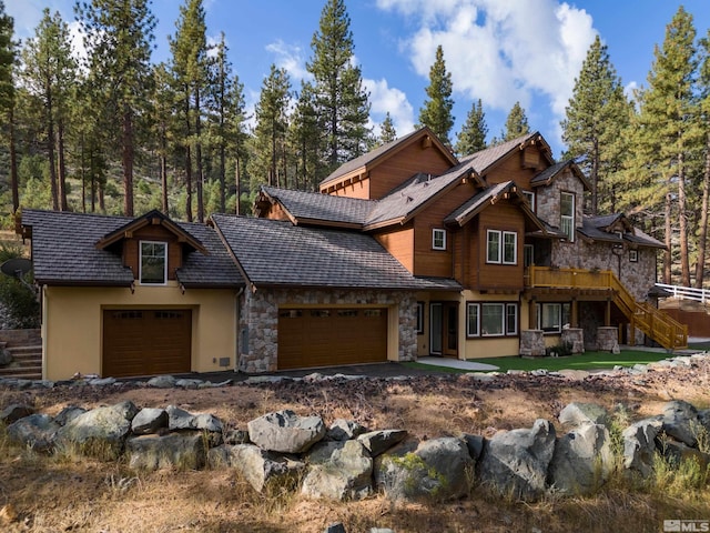 view of front facade with a garage, stairway, stucco siding, and stone siding