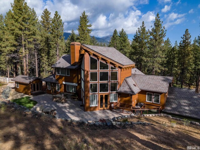 rear view of house featuring an outdoor fire pit, french doors, a patio area, and a chimney