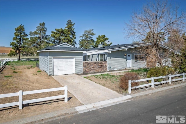 single story home featuring an attached garage, driveway, and a fenced front yard