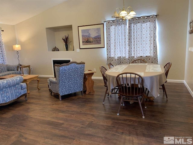 dining area with a fireplace, a notable chandelier, baseboards, and dark wood finished floors