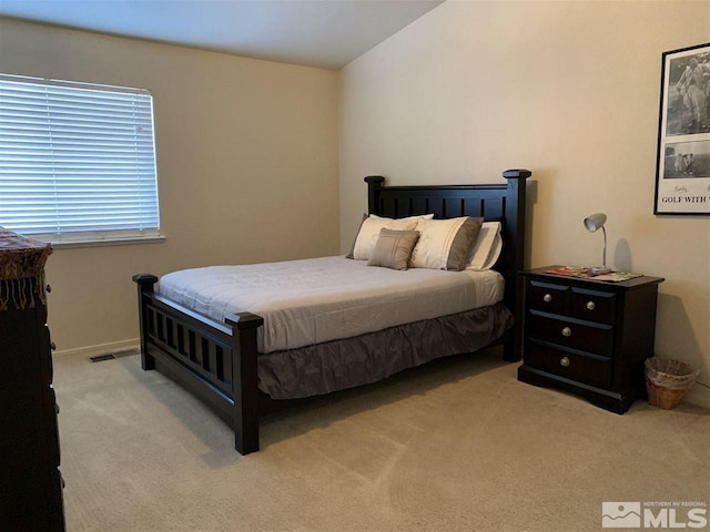 bedroom with light carpet, visible vents, and vaulted ceiling