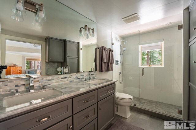 ensuite bathroom with a shower stall, a sink, and toilet