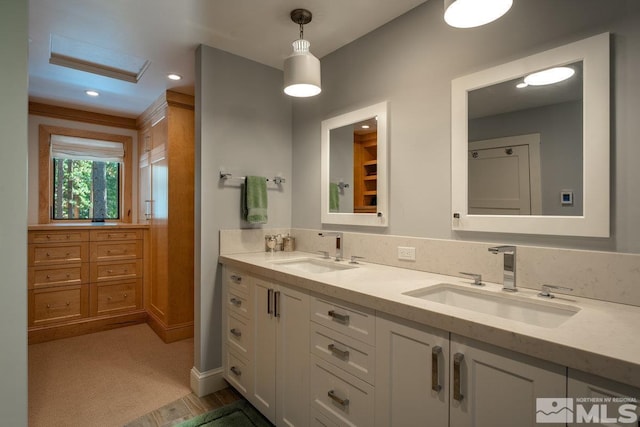 bathroom featuring recessed lighting, double vanity, and a sink