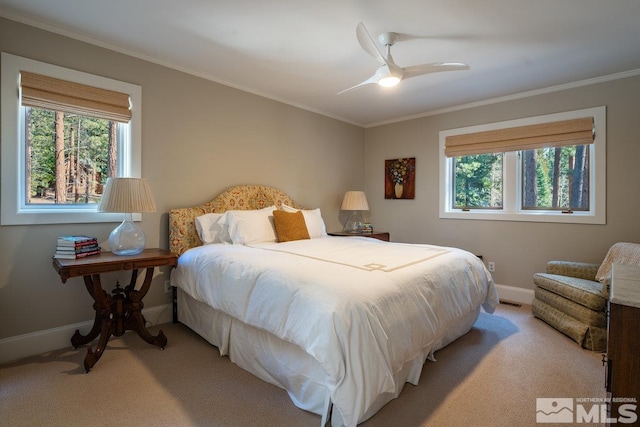 bedroom with ornamental molding, baseboards, ceiling fan, and light carpet