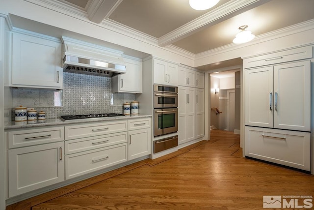 kitchen with light wood-style flooring, gas cooktop, a warming drawer, custom exhaust hood, and backsplash