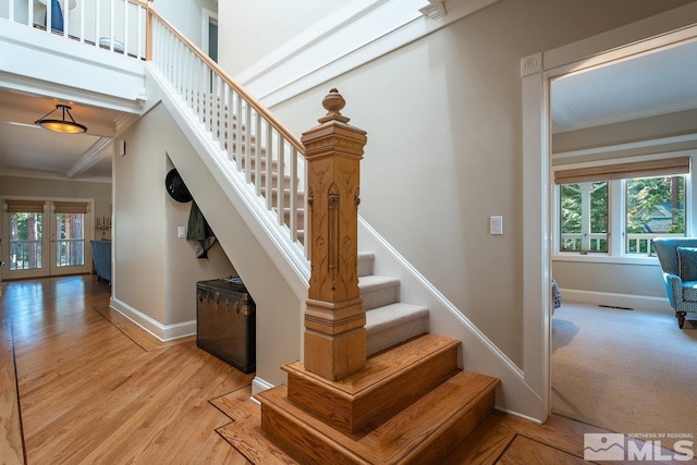 stairs featuring crown molding, baseboards, and plenty of natural light