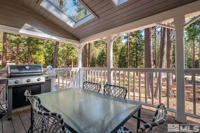 deck featuring outdoor dining space and a grill