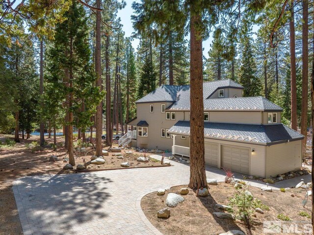view of front of property with roof with shingles, a garage, and driveway