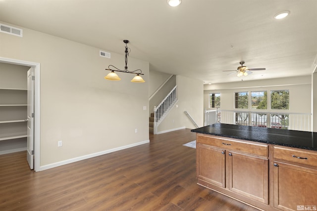 kitchen featuring brown cabinets, ceiling fan, dark wood finished floors, and visible vents