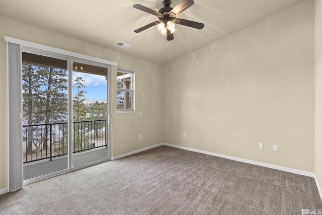 carpeted spare room featuring visible vents, baseboards, and a ceiling fan