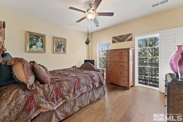 bedroom featuring access to exterior, wood finished floors, a ceiling fan, and visible vents