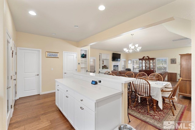 kitchen featuring white cabinetry, light countertops, beam ceiling, and a kitchen island