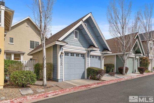 view of front of house featuring an attached garage, fence, and stucco siding