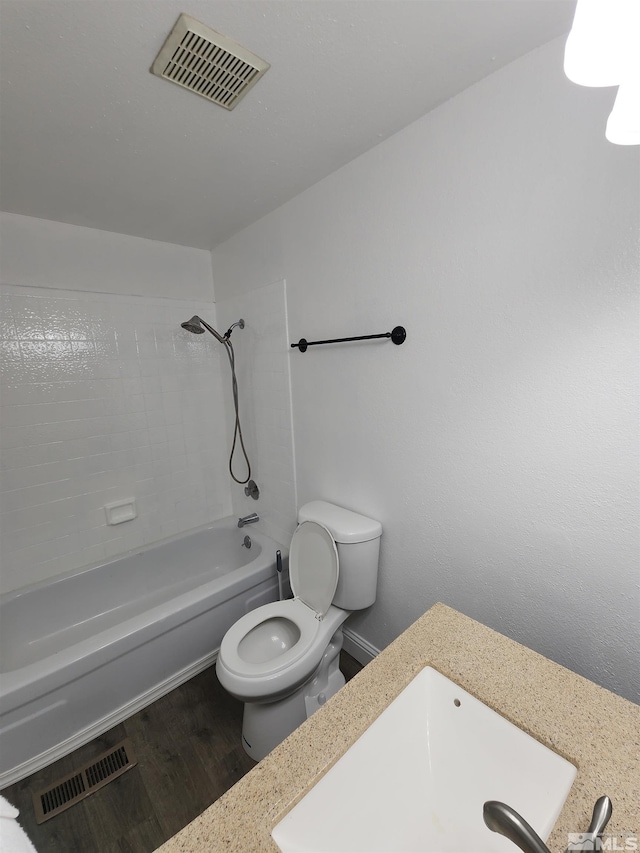 bathroom featuring visible vents, toilet, shower / bath combination, and wood finished floors
