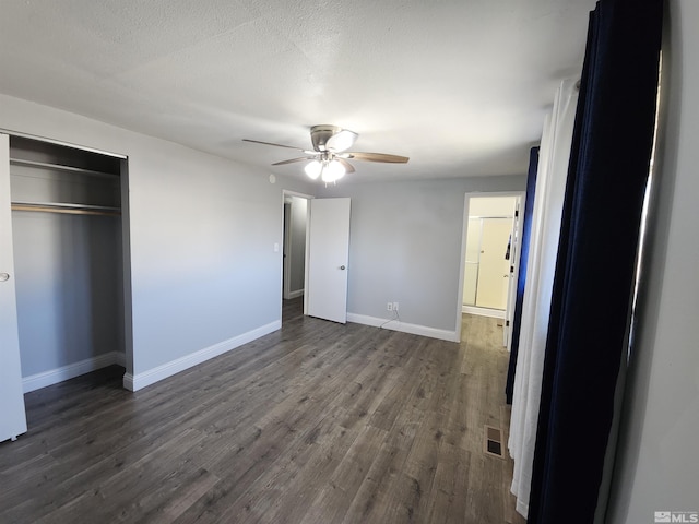 unfurnished bedroom featuring a closet, baseboards, a ceiling fan, dark wood-type flooring, and visible vents