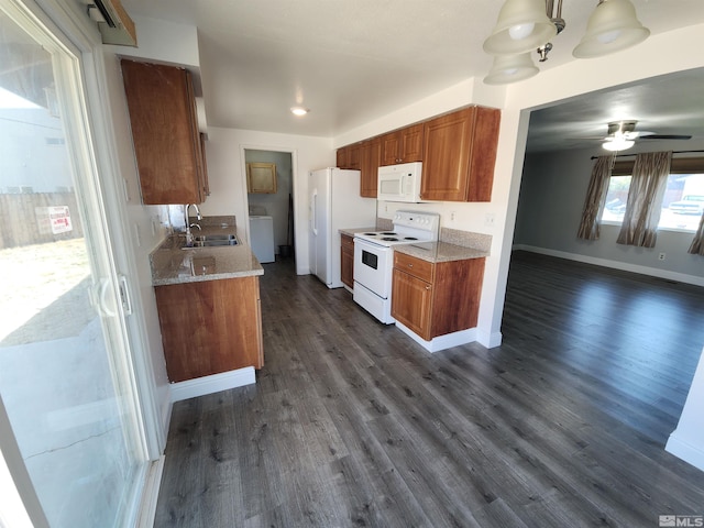 kitchen featuring washer / clothes dryer, white appliances, dark wood-type flooring, brown cabinetry, and a sink