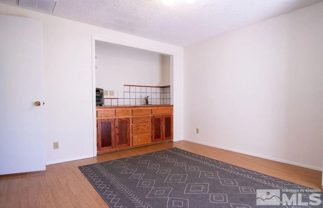 spare room with a sink, visible vents, a textured ceiling, and dark wood finished floors