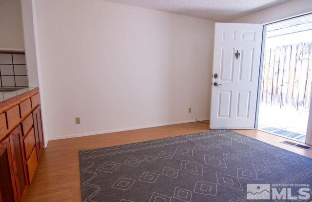 entrance foyer with visible vents, baseboards, and wood finished floors