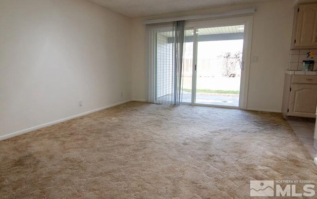 unfurnished room featuring baseboards and light colored carpet
