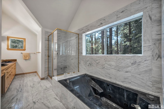 full bathroom featuring vanity, a jetted tub, a marble finish shower, marble finish floor, and lofted ceiling