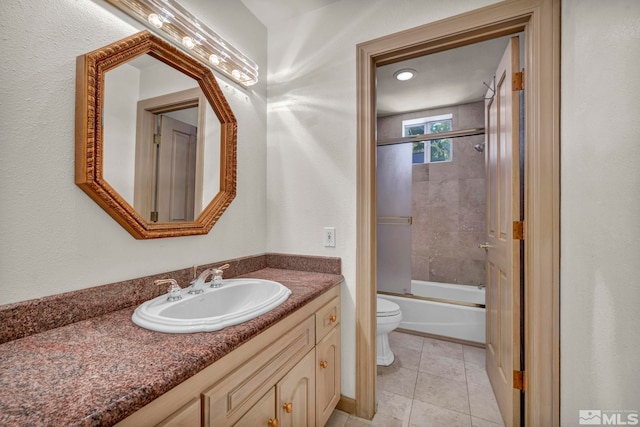 bathroom with tile patterned flooring, toilet, vanity, and shower / bath combination with glass door