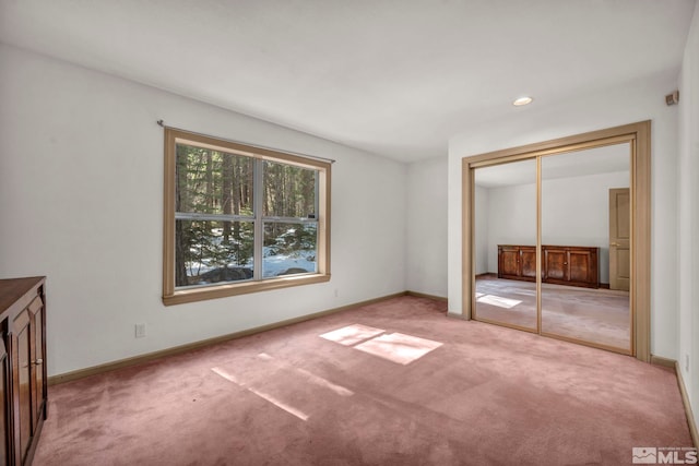 unfurnished bedroom with carpet flooring, a closet, and baseboards