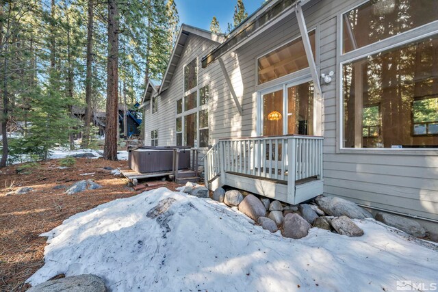 view of home's exterior featuring a deck and a hot tub
