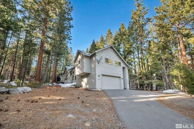view of home's exterior with aphalt driveway and an attached garage