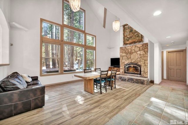 home office with a high ceiling, wood finished floors, a fireplace, and baseboards
