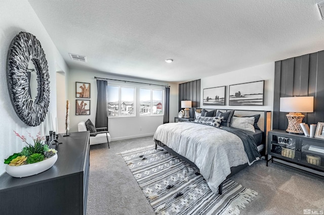 bedroom with visible vents, baseboards, carpet flooring, and a textured ceiling