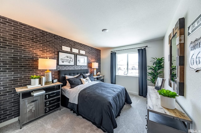 carpeted bedroom with baseboards, brick wall, and a textured ceiling