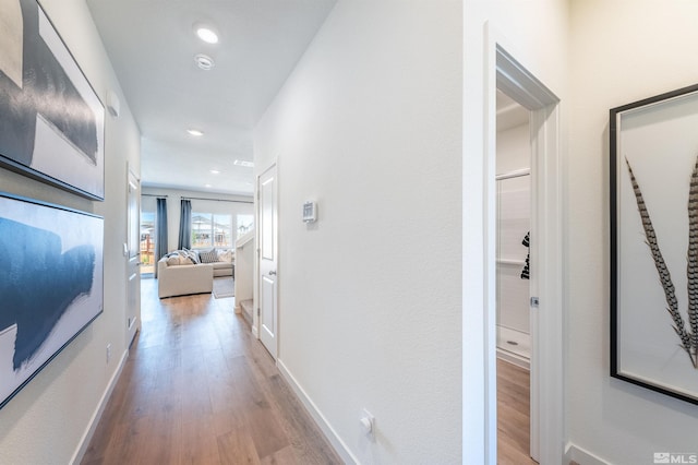 hallway with recessed lighting, baseboards, and wood finished floors